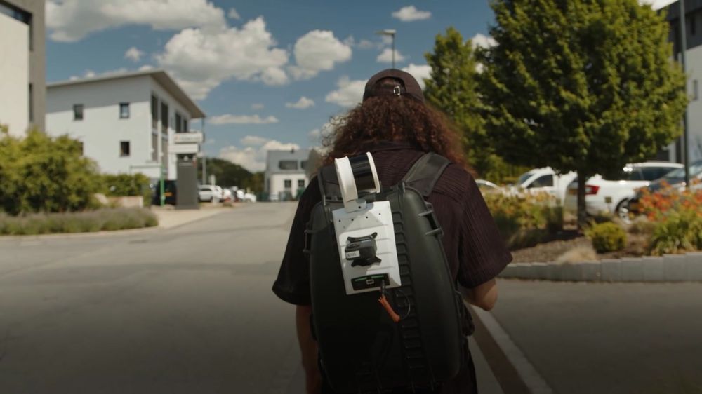 An operator walking away from camera with the Artec Jet mounted on a backpack frame