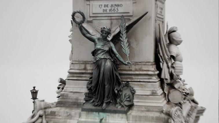 A high-detail 3D capture of a stone monument, showing a winged bronze figure and carved relief